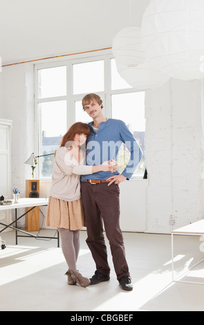 Ein junges Paar, stehend nebeneinander Arme umeinander Stockfoto