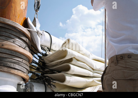 Hintere Mittelteil des Mannes neben Segel und Mast eines Segelbootes Passagier Nahaufnahme Stockfoto
