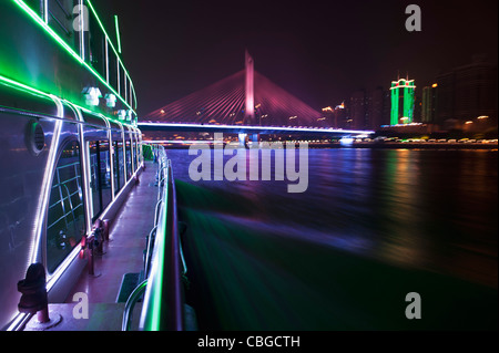 Yacht auf Pearl River in Hong Kong und beleuchtete Haiyin Brücke im Hintergrund Stockfoto