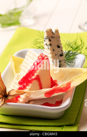 Stücke von zarten Käse garniert mit Himbeer-Balsamico-Reduktion Stockfoto