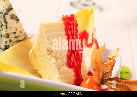 Stücke von zarten Käse garniert mit Himbeer-Balsamico-Reduktion Stockfoto