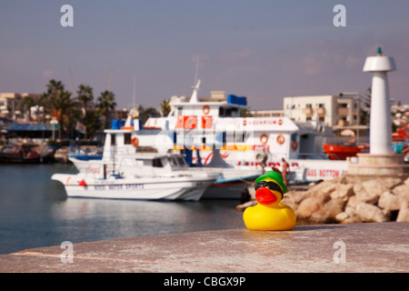 Gelb, Kunststoff-Spielzeug Ente posiert auf der Hafenmauer, Ayia Napa, Zypern. Stockfoto