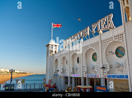 Brighton Pier Staycation mit Union Jack Flagge fliegen und sonnenbeschienenen Strand hinter Brighton West Sussex England Großbritannien Stockfoto