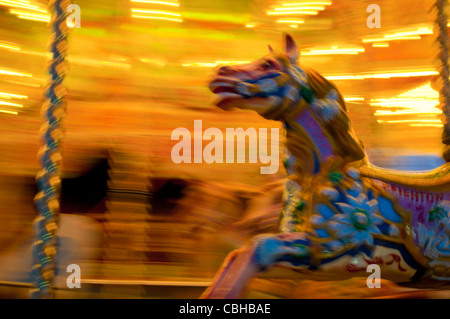 Karussell-Pferd mit Motion blur unterwegs einen hell erleuchteten frohe Runde, Brighton, UK Stockfoto