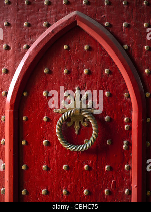 Alte Studentür Gotische historische hölzerne rote Messing verziert Kirche Eingangstür zu Winchester Cathedral Hampshire UK Stockfoto