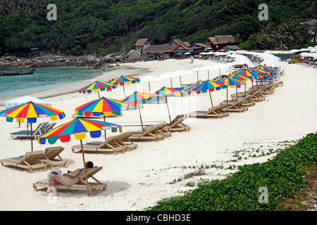 Liegestühle und Sonnenschirme am Sandstrand Urlaub Strand von Patok Bay auf Raya Insel, Phuket, Thailand Stockfoto