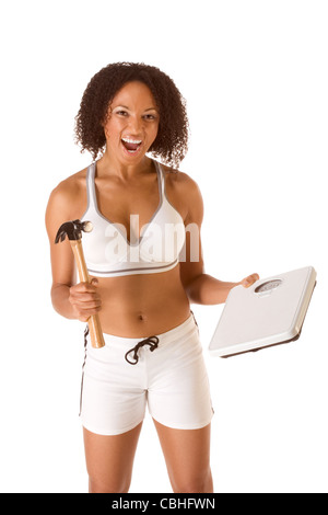 Ethnische Frau im sportlichen Outfit hits Waage von hammer Stockfoto