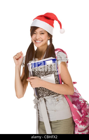 Asiatische Schulmädchen rote Weihnachtsmann Hut mit Rucksack hält Zusammensetzung Buch, Notizbücher Stockfoto