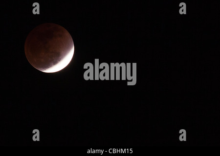 Die totale Mondfinsternis vom 10. Dezember 2011, von Mumbai aus gesehen, zeigte einen tiefroten „Blutmond“, als der Schatten der Erde den Mond vollständig bedeckte. Stockfoto