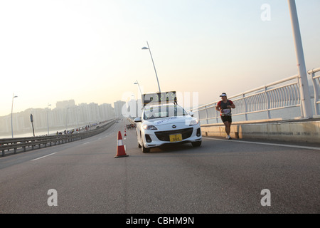 Macau Marathon, Uhr Auto zusammen mit Athleten, Macau Stockfoto