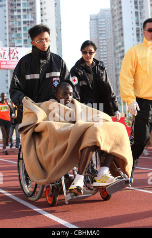 Marathon-Athleten genommen im Rollstuhl an der Ziellinie, Macau Marathon Stockfoto