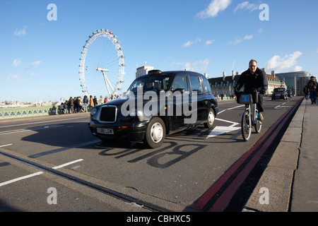 Mann auf gemieteten Zyklus überholt durch schwarzes Londoner Taxi Taxi auf Westminster Bridge in central London England Vereinigtes Königreich Großbritannien Stockfoto