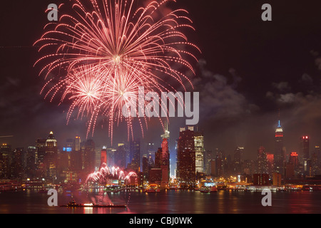 Die Macy's 4. Juli leuchtet den Himmel über die Skyline von Midtown Manhattan Feuerwerk und Hudson River in New York City. Stockfoto
