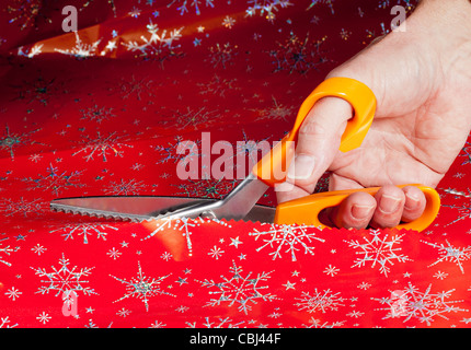 Weihnachts-Papier durch spezielle Schere Muster in die Schnittkante erstellen Stockfoto