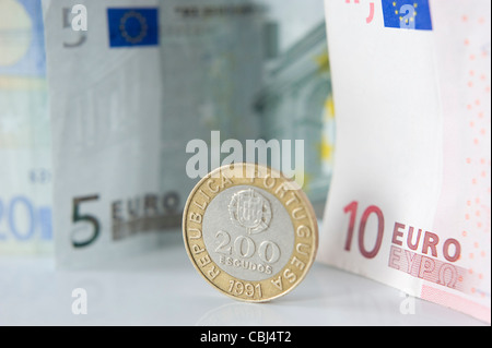 Alte portugiesische Escudo Münze neben Euro-Scheine Stockfoto