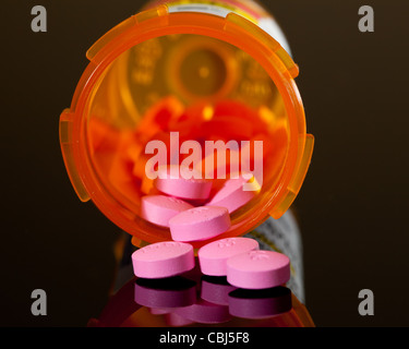 Satz von Runde lila Tabletten aus einer orange Pille Flasche gießen Stockfoto