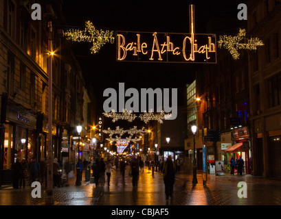 Weihnachtsbeleuchtung, hängt Weihnachtsdekoration über Henry Street in Dublin, Irland, Baile aha Tuch, gälischen Schilder, Shopper auf der Henry Street Stockfoto