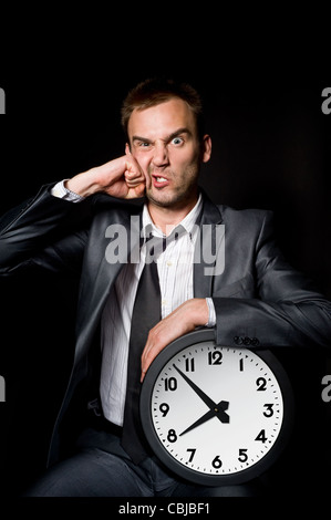 junger Geschäftsmann in seinem Gesicht über schwarz gelocht Stockfoto