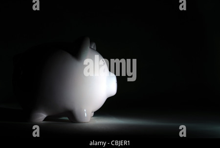 PIGGY BANK IN DÜSTEREN LICHT RE WIRTSCHAFTLICHE TRÜBSINN REZESSION ABSCHWUNG EINSPARUNGEN FINANZIELLE EINSPARUNGEN ETC. UK PIGGY SPARDOSE Stockfoto