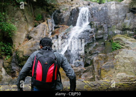 Wilde trekking Reisende in der Nähe von natürlichen Dschungel Wasser fallen vorbereiten durch Felsen im dichten Wald Klettern Stockfoto