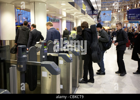 Passagiere mit Ticket Barriere Maschinen bei Waterloo Schiene Station London England Vereinigtes Königreich Großbritannien Stockfoto