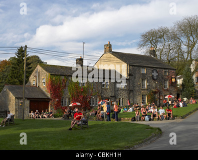 Menschen, die vor dem Pub des Lister Arms Hotels aus dem 17. Jahrhundert sitzen Malham Malhamdale in der Nähe Skipton North Yorkshire England Vereinigtes Königreich Großbritannien Stockfoto