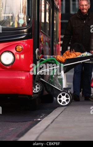 ein Kinderwagen, einem Baby der Verladung in einem roten Londoner bus Stockfoto