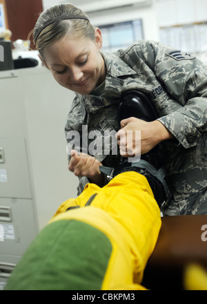 Senior Airman Lynette Keeton zieht die Stiefel von Capt. Peter J. Gryns Fluganzug am 4. Oktober 2009 an. Der Kampf war Captain Gryn's erste Kampfmission. Beide Airmen sind von der Beale Air Force Base, Kalifornien, aus eingesetzt. Stockfoto