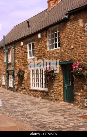 Terrassenförmig angelegten Reihe von schönen alten englischen Steinhütten in engen gepflasterten Straße, Oakham, Rutland, England, UK Stockfoto