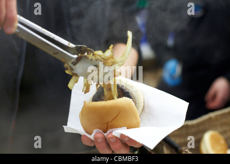 Mann, Zwiebeln in einen Burger in einem Stall in Belfast Nordirland Großbritannien Vereinigtes Königreich Stockfoto