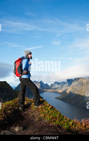 Weibliche Wanderer genießt Aussicht über Berge und Fjorde von Reinebringen, Lofoten Inseln, Norwegen Stockfoto