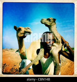 Schwarze Reife Mann, hält Baby Kamelhaar auf seinem Rücken, Lughaya Bereich, Somaliland Stockfoto