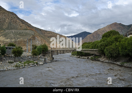 Die Brücke über schnelle, wohlhabend und schlammigen Bergfluss Nepal in der Nähe von Jomsom Dorf Stockfoto