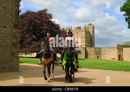 Ritter und knappen fahren aus der Great Court of Bolsover Castle. Die kleine Burg ist hinter der Wand des Stein-Walk. Stockfoto