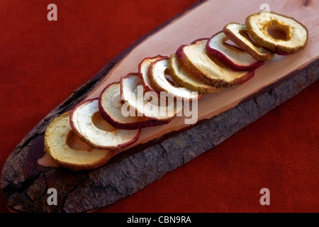 Apfelchips aus getrocknete Apfelringe auf einem Holzbrett Stockfoto