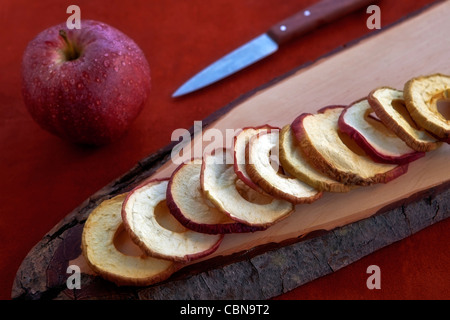 Apfelchips aus getrocknete Apfelringe auf einem Holzbrett Stockfoto