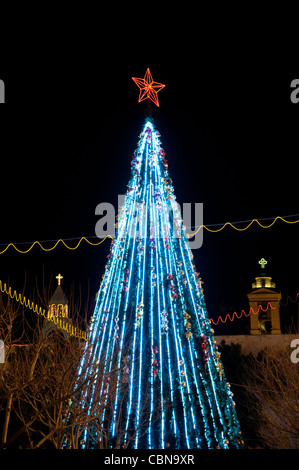 Ein Weihnachtsbaum wird durch die Türme der Bethlehem Kirche der Geburt, traditionellen Standort des Geburtshauses von Jesus flankiert. Stockfoto