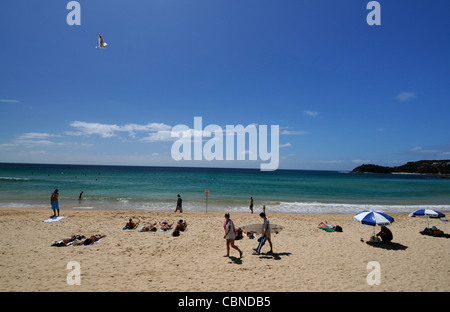 Sonnenanbeter und Surfer am Manly Beach am Pazifischen Ozean in der Nähe von Sydney in New South Wales, Australien. Stockfoto