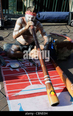 Ein Aborigine-Straßenmusiker spielt sein Didgeridoo am Circular Quay in Sydney Stockfoto