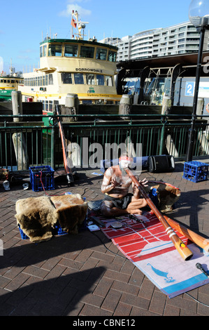 Ein Aborigine-Straßenmusiker spielt sein Didgeridoo am Circular Quay in Sydney, New South Wales, Australien Stockfoto