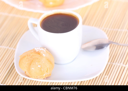 Tasse Kaffee und Kuchen auf Holzmatte, Nahaufnahme Stockfoto