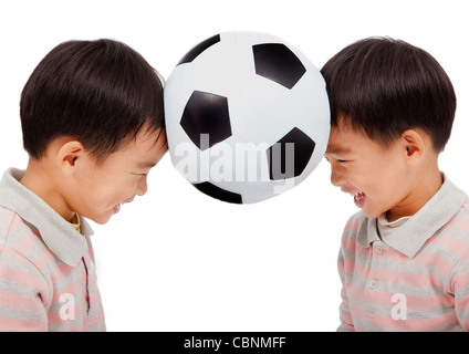 glückliche Kinder, die einen Fußball über ihrem Kopf halten Stockfoto