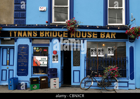 frontale Vorderansicht, Tynans Haus Bar Kneipe überbrücken lizenziert Räumlichkeiten Kilkenny Irland blau Attraktion Fahrrad Fahrrad Blumenkorb Stockfoto