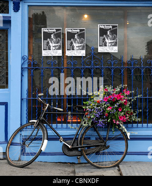 frontale Vorderansicht, Tynans Haus Bar Kneipe überbrücken lizenziert Räumlichkeiten Kilkenny Irland blau Attraktion Fahrrad Fahrrad Blumenkorb Stockfoto