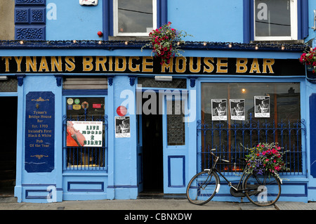 frontale Vorderansicht, Tynans Haus Bar Kneipe überbrücken lizenziert Räumlichkeiten Kilkenny Irland blau Attraktion Fahrrad Fahrrad Blumenkorb Stockfoto