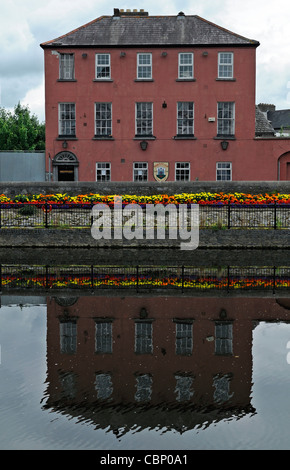 Blume-Display vor der Selbstverwaltung Club Johns Kai Spiegeln reflektiert Reflexion Fluss Nore Kilkenny Irland Stockfoto