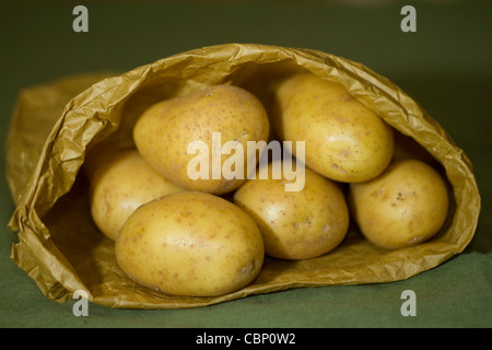 Kartoffeln in eine braune Papiertüte auf einem urigen grüner Hintergrund Stockfoto