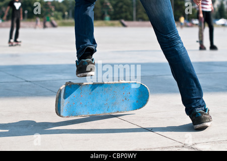 junge Skater segelnder Stunt auf seinem blauen Brett Stockfoto