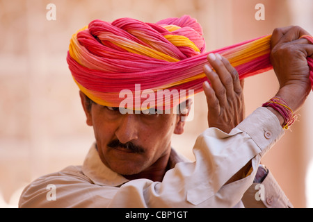 Hindu zeremonielle Garde aufsetzen Rajasthani Turban an Mehrangarh Fort in Jodhpur in Rajasthan, Nordindien Stockfoto
