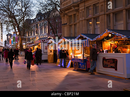 Weihnachts-Einkäufer mit saisonalen Verkaufsständen in Straße Cardiff City centre Wales UK Stockfoto